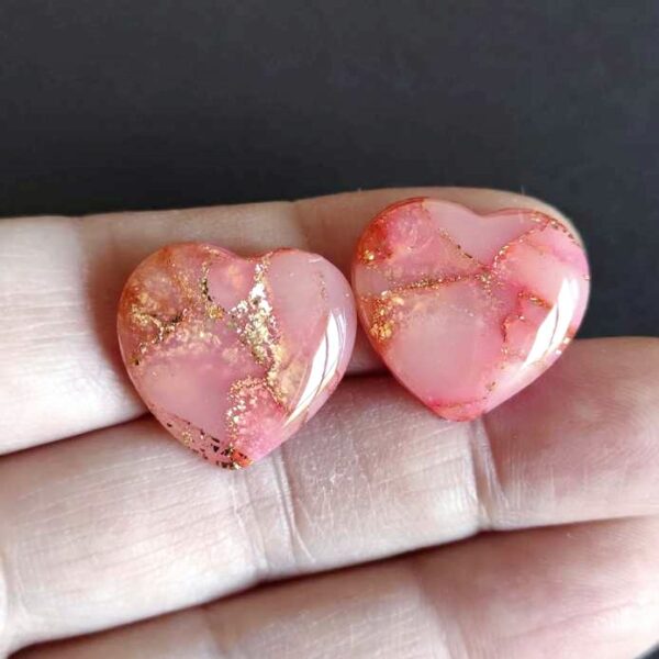Due cabochon hand made in argilla polimerica a forma di cuori, semitrasparenti, colore oro e rosa.